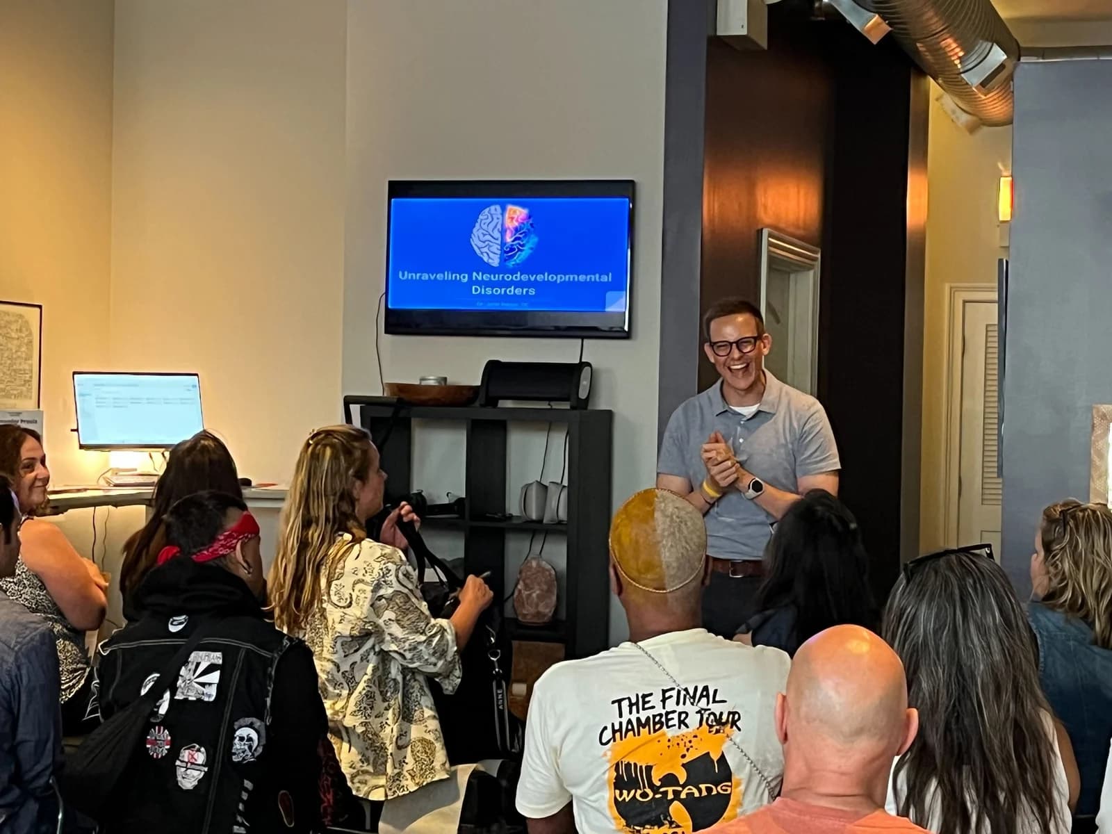 A presenter sharing a laugh with a full workshop room