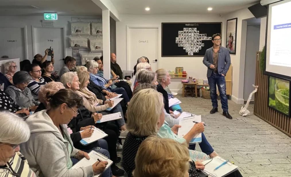 A full room of attendees taking notes at a live workshop